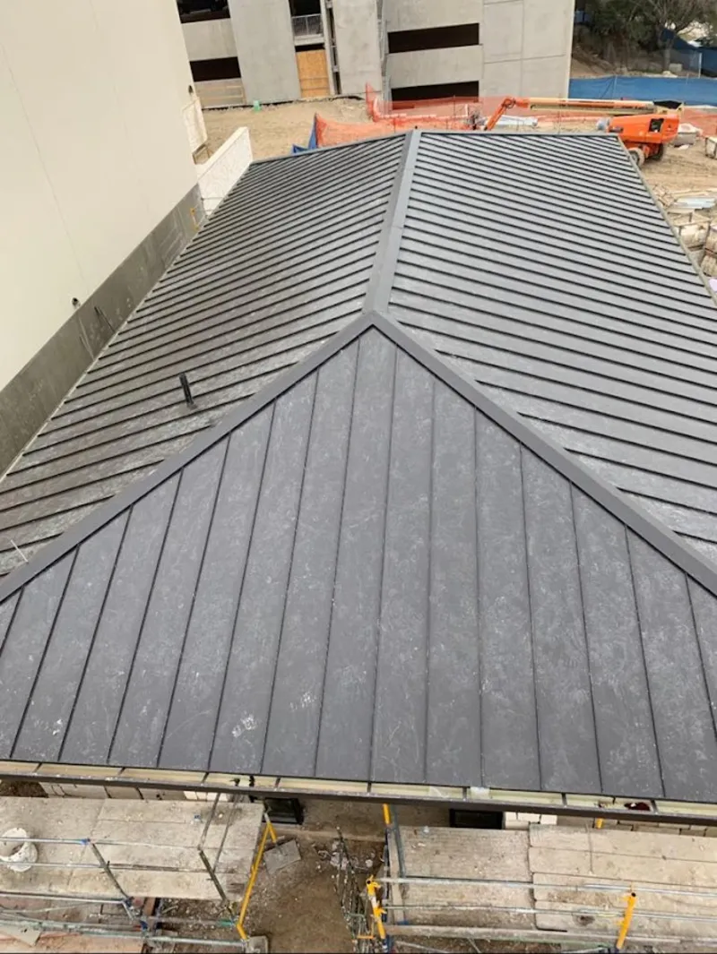 Commercial metal roof construction with crane equipment in South Burlington